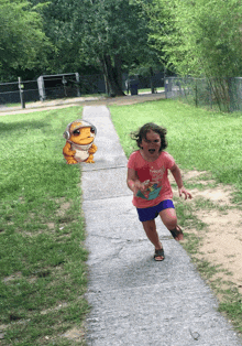 a little girl is running down a sidewalk in front of a frog that says ' i love you ' on it