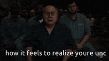 a man sitting in front of a crowd with the words how it feels to realize youre unc written below him
