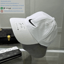 a white nike hat sits on a mannequin with the website www.ecwholesaler.ru in the background