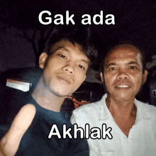 two men are posing for a picture with the caption " gak ada akhlak " above them