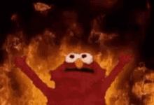 elmo from sesame street is surrounded by flames and smoke .