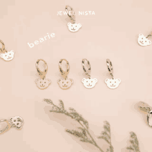 jewel nista bearie earrings are displayed on a pink background