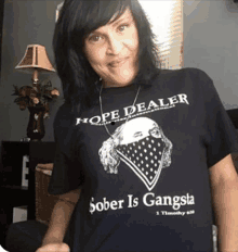 a woman wearing a hope dealer sober is gangsta shirt