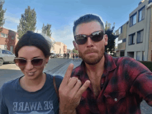 a man and a woman are posing for a picture and the woman is wearing a shirt that says aawa 38