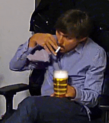 a man smoking a cigarette and drinking a beer