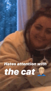 a woman laying on a bed with a cat and the words hates attention with the cat
