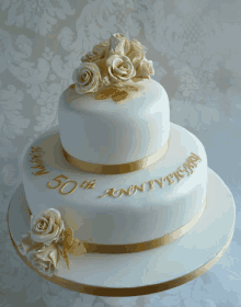 a 50th anniversary cake with white roses on top