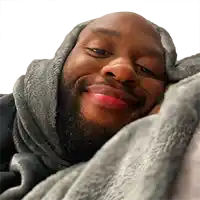 a man wrapped in a grey blanket is smiling