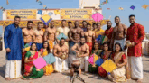 a group of people are posing for a picture in front of a sign that says happy uttarayan makar sankranti pongal
