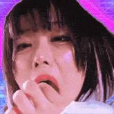 a close up of a woman covering her mouth with her hand and yawning .