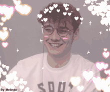 a boy wearing glasses and a shirt that says so04 smiles with hearts around him