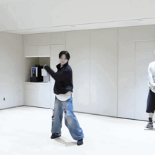 a man in a black sweater and blue jeans is dancing
