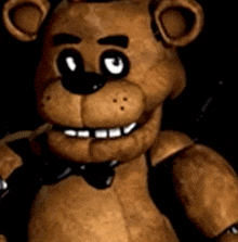 a close up of a teddy bear wearing a bow tie and smiling .
