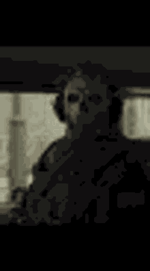 a black and white photo of a man wearing headphones and a mask .