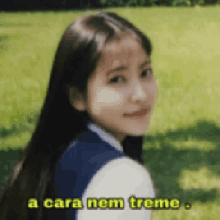 a girl with long hair is standing in the grass with the words a cara nem treme