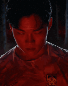 a close up of a man 's face with red lights behind him