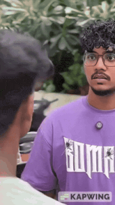 a man wearing a purple shirt that says puma