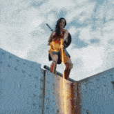 a woman in a wonder woman costume is standing on a bridge holding a sword