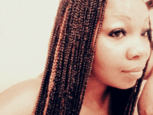 a woman with braids looks at the camera with a white background