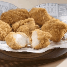 a basket of fried chicken nuggets with a bite taken out of one