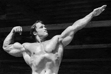 a black and white photo of arnold schwarzenegger flexing his arms .