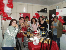 a group of people standing around a table with a bottle of coca cola