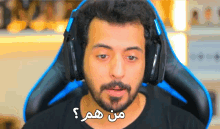 a man with a beard wearing headphones with arabic writing on the front