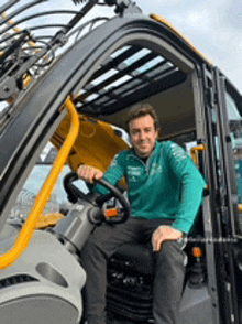 a man is sitting in the driver 's seat of a tractor .