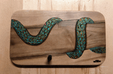 a painting of a snake on a wooden board