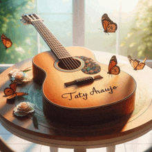 a guitar with the name taty araujo on it sits on a table