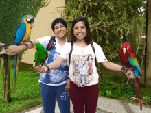 a woman wearing a t-shirt with a picture of a man and a woman holding a parrot