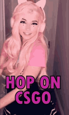 a girl with pink hair is wearing headphones and a pink shirt with the words hop on csgo written on it .