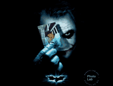 a poster of the joker holding a playing card with a picture of a man on it