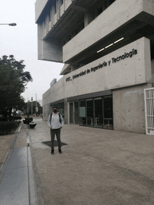 a man wearing a mask is standing in front of a building that says universidad de ingenieria y tecnologia