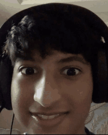 a young man wearing headphones is making a funny face .