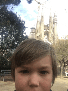 a young boy takes a selfie in front of a large building