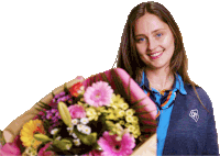 a woman holding a bouquet of flowers wearing a blue shirt with the letter h on the front