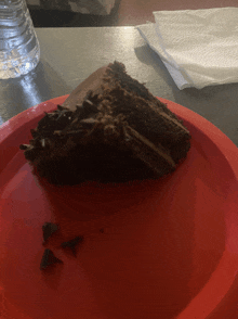 a piece of chocolate cake on a red plate