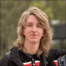 a young man with long blonde hair is wearing a backpack