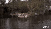 a man stands on a small island in the middle of a lake with a netflix logo in the corner