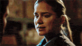 a close up of a woman 's face with a ponytail