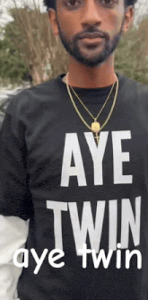 a man wearing a black shirt that says aye twin aye twin
