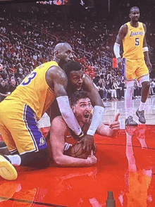 a basketball player with the number 5 on his shorts is kneeling down