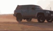 a gray suv is driving through a desert with a license plate that says ' aa ' on it