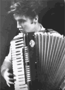 a black and white photo of a man playing a accordion