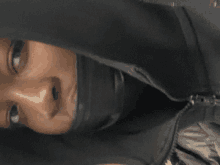 a close up of a person 's face with a hood on