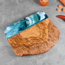 a wooden cutting board with a blue and green resin border