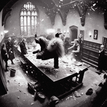 a black and white photo of a group of people standing around a table