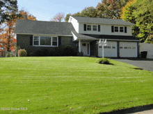 a picture of a house taken by global mls shows a lush green lawn