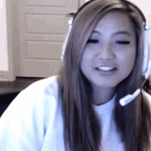 a woman wearing headphones and a headset looks at the camera